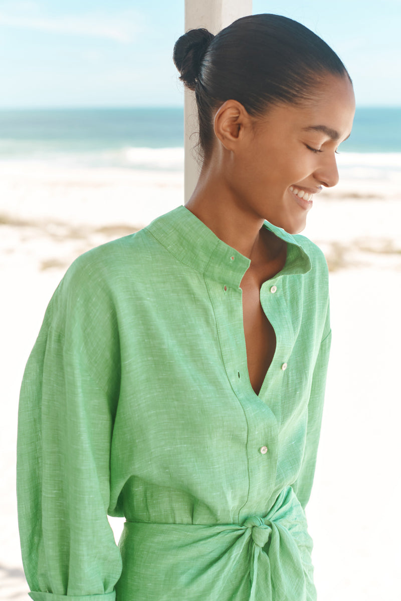 Wiggy Kit | Mini Sarong Shirt Dress | Model wearing green shirt dress with beach background