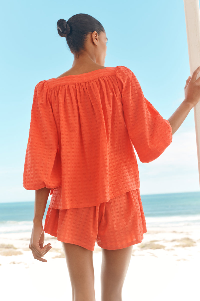 Wiggy Kit | The Pocket Short | Model wearing orange shorts with matching shirt