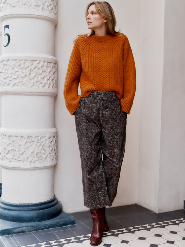 A model wearing the Wiggy Kit Cord Chore Pants and Orange Slouch Fisherman's Crew jumper standing with hands in pockets.