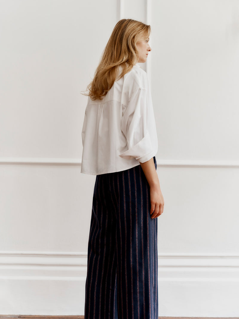 Wiggy Kit model wearing The Ledbury Pant and Boxer Shirt stood facing towards a panelled wall.