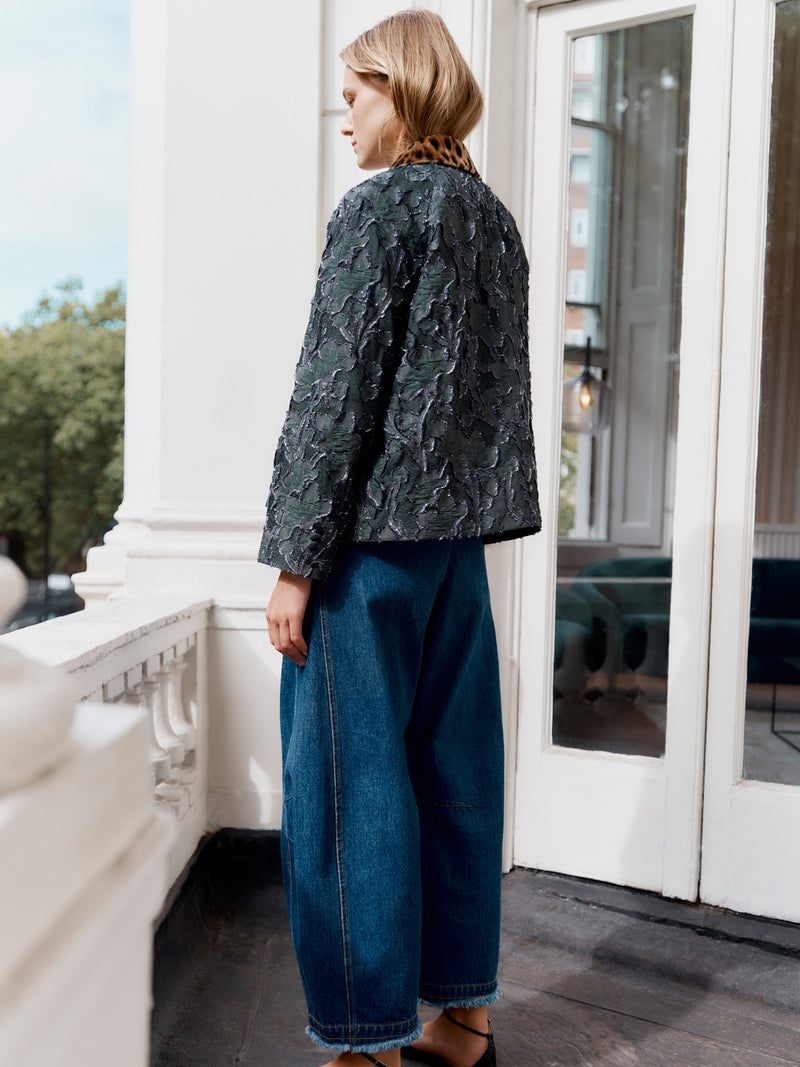 Wiggy Kit model wearing the Mercer Jacket and Rancho Jean facing away on a balcony.