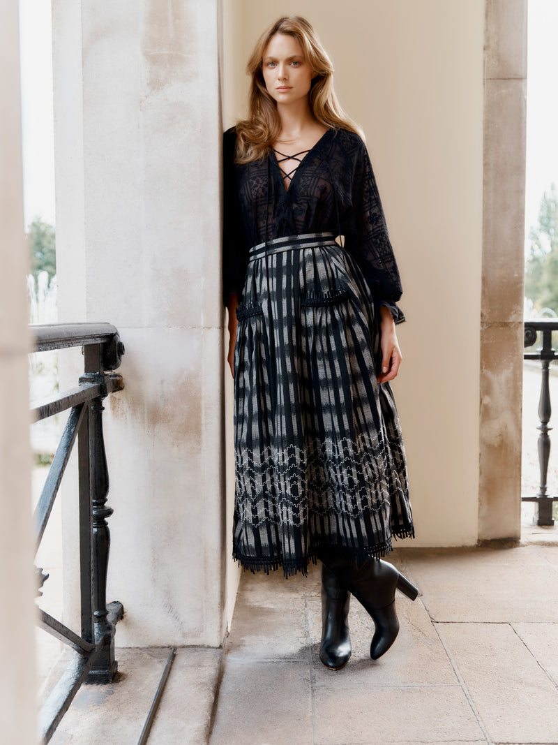 Wiggy Kit model wearing the Embroidered Gaucho Skirt and Pirate Shirt leaning on a wall.