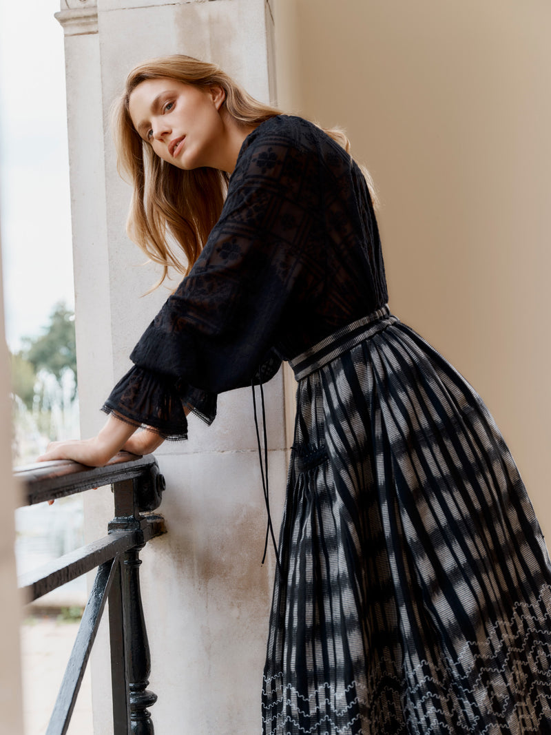 Wiggy Kit model wearing the Embroidered Gaucho Skirt and Pirate Shirt leaning on balcony railing.